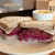 Hitchcock Deli's pastrami sandwich on rye with cabbage slaw, Swiss cheese, and Russian dressing. Option to get it "piled high" with a half-pound of meat, or New York style with a pound. Served with chips.